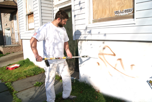 Photos by Karen Zautyk John Donovan (top) and Deaglan Walsh and Martin Macedonio rid Elm St. of graffiti blight.