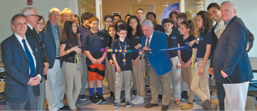 Photos by Ron Leir Harrison Board of Education members, from l., Frank Nascimento (also Washington School Vice Principal), Anthony Comprelli, Lilly Wang, Arthur Pettigrew, Kim Woods and Vincent Franco (cutting ribbon), along with Washington School Administrator in Charge Peter Santana and Superintendent James Doran, and students at offi cial opening of Cafe Ole.