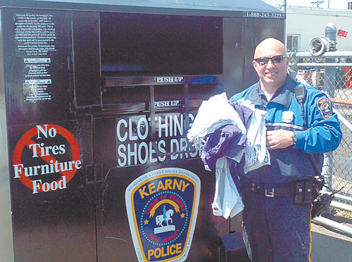 Photo courtesy KPD Officer Damon Pein makes a donation at the new KPD clothing/shoes collection bin off Bergen Ave.