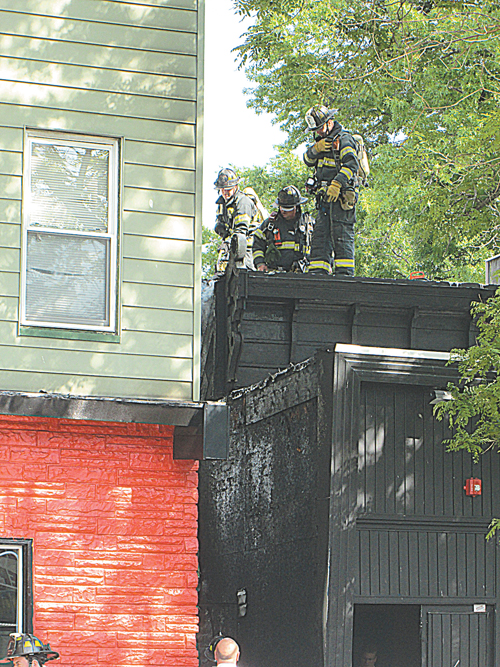 Photos by Ron Leir Firefighters (top) spray walls on either side of alleyway between 498 and 500 Kearny Ave. and (bottom) vent roof of 498 Kearny Ave.