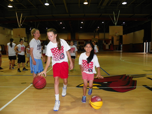 Photo by Jim Hague As Kearny High School head coach Jody Hill (far l.) looks on, Meagan McClelland (l.) and Emily Angeles display some of their ball handling skills at the annual Kearny High School Girls’ Basketball Camp recently