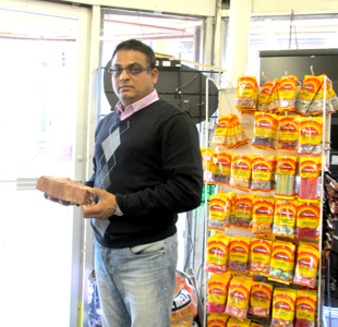 Photo by Ron Leir Hitesh Patel holds brick that a burglar used to shatter his glass door.